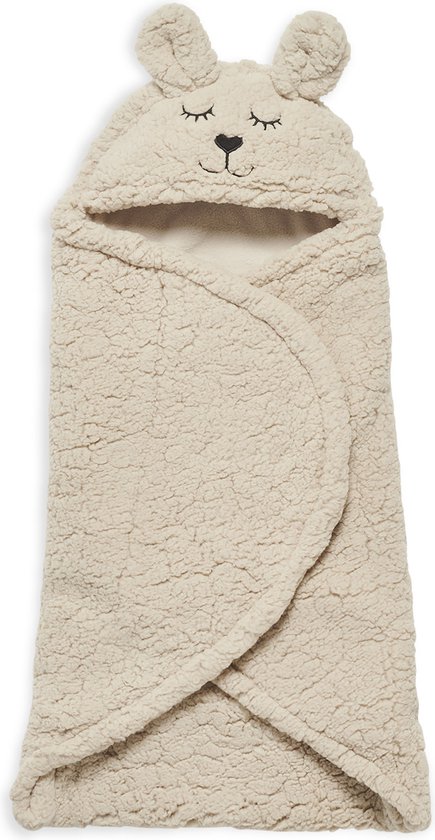 Beige baby wikkeldeken met konijnenoren, geborduurde ogen en neus, gebreide textuur.