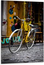 WallClassics - Dibond - Gele Fiets bij Geel Gebouw in de Stad - 80x120 cm Foto op Aluminium (Met Ophangsysteem)