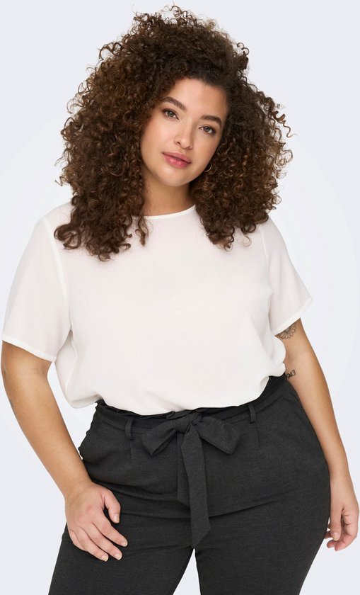 Gros plan d'un mannequin aux cheveux bruns bouclés, portant un haut blanc et un pantalon gris foncé avec ceinture à nouer.