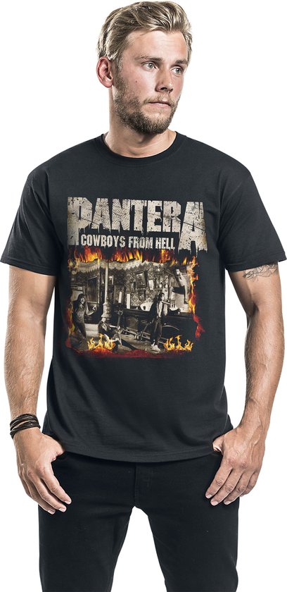 Man met lang bruin haar, stoppels en baard, draagt een zwart t-shirt met de "PANTERA COWBOYS FROM HELL" print en vuurmotief.