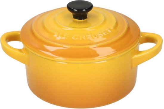 Gele Le Creuset mini braadpan met zwarte knop en handvatten, op witte achtergrond.