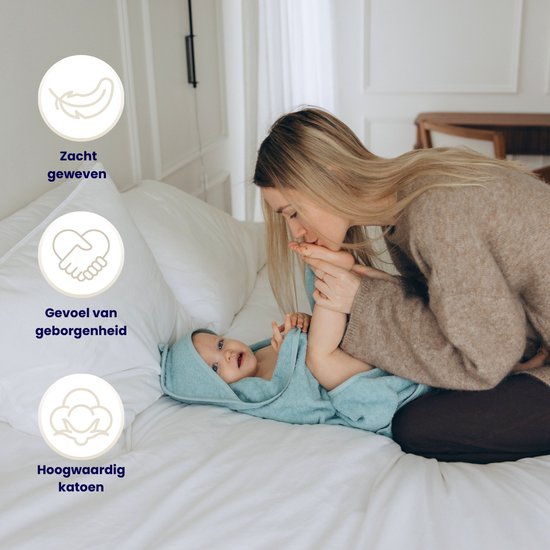 Mère embrassant le pied d'un bébé, bébé dans une cape de bain bleue. Icônes pour la douceur, la sécurité et le coton.