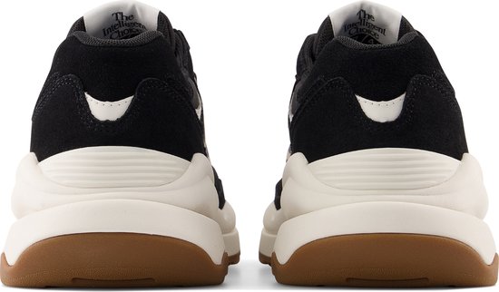 Achterkant van zwarte New Balance sneakers met beige zool en witte accenten.