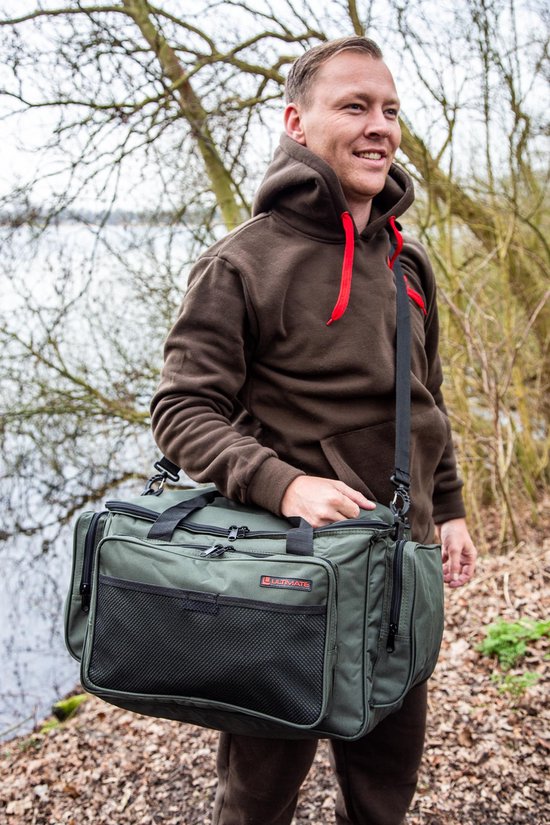 Man met bruine hoodie draagt een donkergroene 'Ultimate' tas met een mesh-vak.