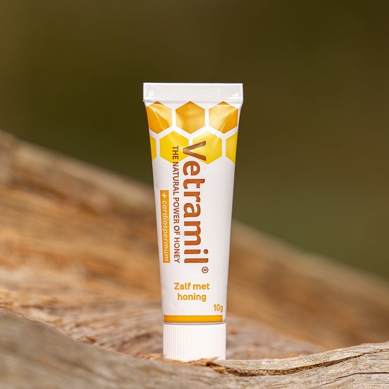 Vetramil zalf met honing 10g tube op een houten ondergrond.