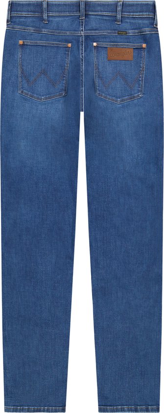 Achterkant van een regular fit spijkerbroek in blauw denim, met bruin Wrangler logo op de rechterzak.