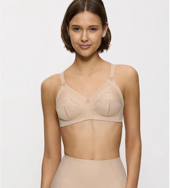 Model in een huidkleurige beha met geborduurde bloemenpatronen, kanten details en strikjes op de bandjes.