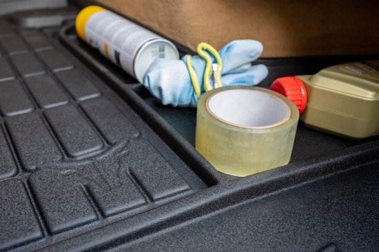 Een rol ducttape, handschoenen en een spuitbus op een zwarte automat.