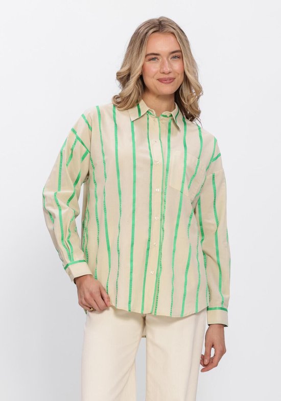 Model in beige oversized blouse met verticale groene strepen, lange mouwen en een casual pasvorm. Draagt een lichte wijde broek.