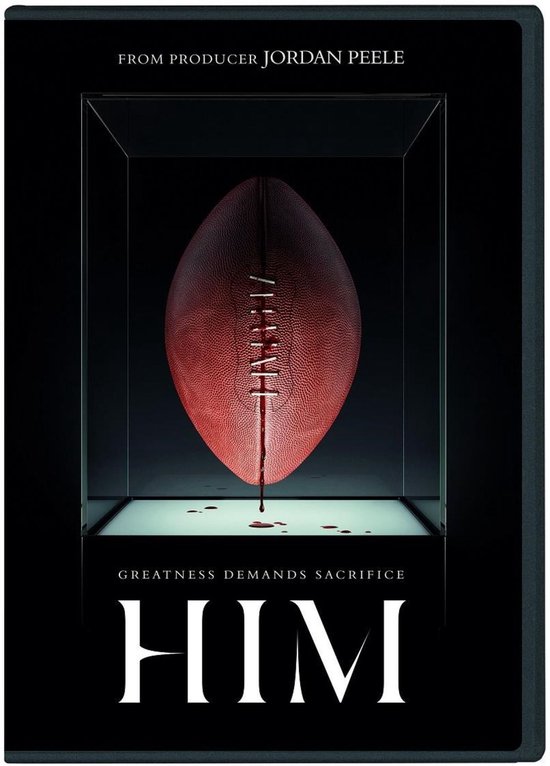 Un ballon de football rouge avec des gouttes de sang sur les lacets, exposé dans une vitrine avec les textes 'GREATNESS DEMANDS SACRIFICE' et 'HIM'. Par le producteur Jordan Peele.