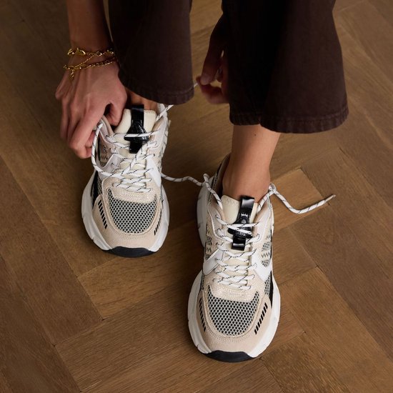 Baskets beiges en cuir avec lacets blancs, détails en mesh noir et beige.