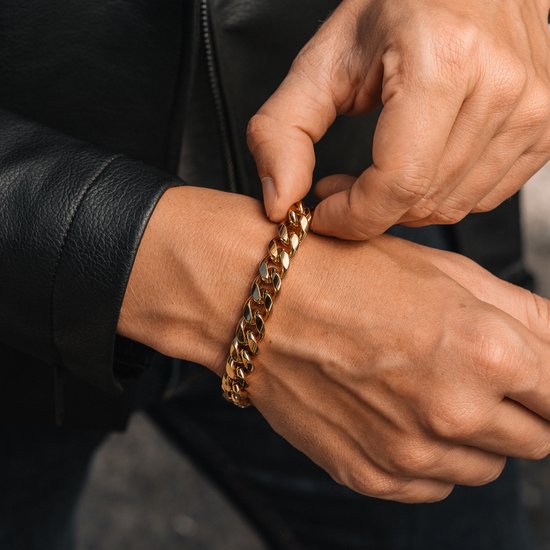 Close-up van mannenhand die een gouden schakelarmband om zijn pols vastzet.