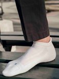 Witte Falke enkelsok met blauw 'R' logo op de tenen en een gebreid patroon.