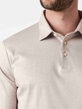 Close-up van de kraag en knopen van een beige longsleeve poloshirt.