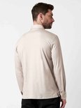 Man met rug naar de camera, draagt beige longsleeve poloshirt.
