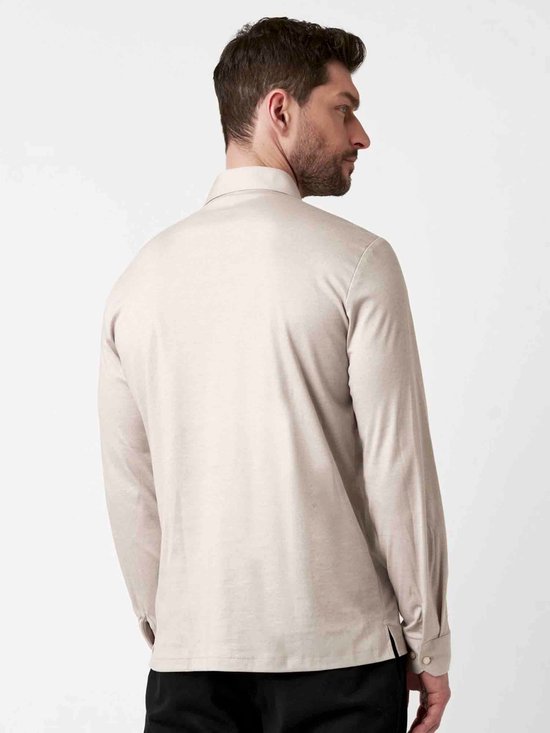 Man met rug naar de camera, draagt beige longsleeve poloshirt.