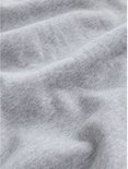 Close-up van de zachte grijze katoenen stof van de sweater met subtiele kreukels.