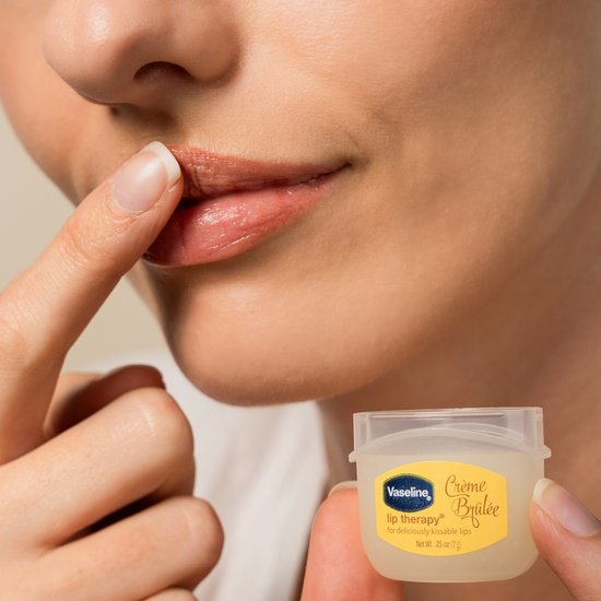 Vrouw brengt Vaseline Crème Brûlée lippenbalsem aan op haar lippen
