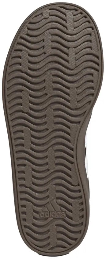 Onderkant van een zwarte Adidas sneaker met een bruine zool met golvend profiel.