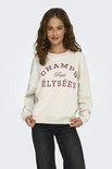 Model draagt een lichtgrijze sweater met 'CHAMPS Paris ÉLYSÉES' opdruk, gecombineerd met zwarte jeans.