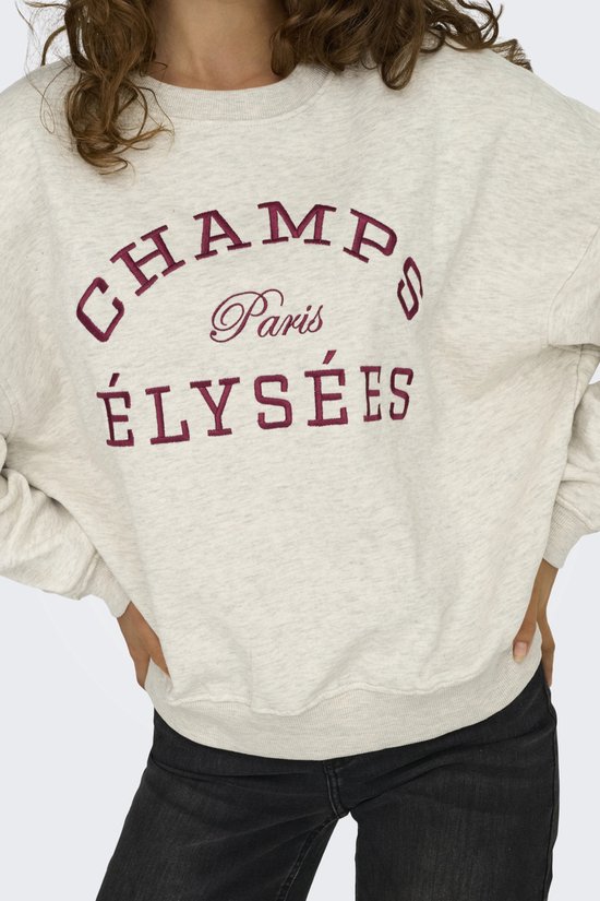 Close-up van een lichtgrijze sweater met geborduurde tekst 'CHAMPS Paris ÉLYSÉES' in donkerrood.