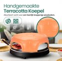 Oranje terracotta koepel van de pizza gourmetset, met een close-up van de textuur.