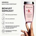 Main tenant une bouteille Kérastase Genesis Bain Hydra-Fortifiant, avec des informations sur 95% de plastique recyclé, sans parabène et sans silicone.