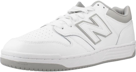 Witte lage sneaker van New Balance met grijze accenten en een groot grijs 'N' logo op de zijkant.