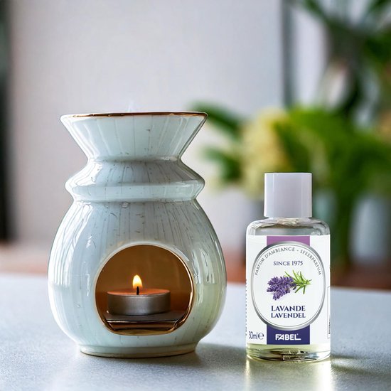 Wit keramisch geurhuisje met brandende theelichtje en flesje lavendelparfum ernaast.