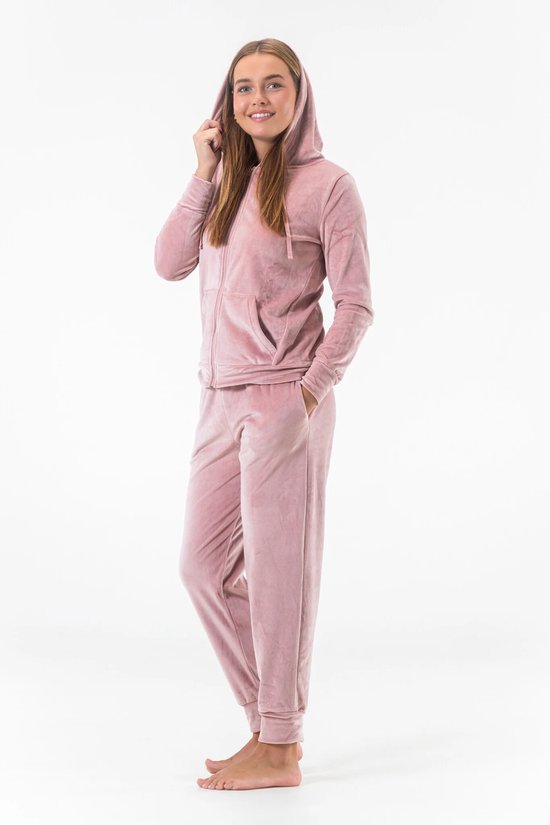 Roze fluwelen joggingpak met capuchon en rits, gedragen door een vrouw.