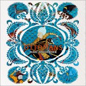 Boek 'The Ottomans' met een centrale afbeelding van een Ottomaanse heerser te paard in een groen en goudkleurig gewaad, omringd door blauwe patronen en decoratieve motieven met dieren.