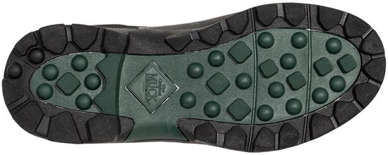 Gedetailleerde opname van een zwarte laars met een groen Muck Boot profiel.