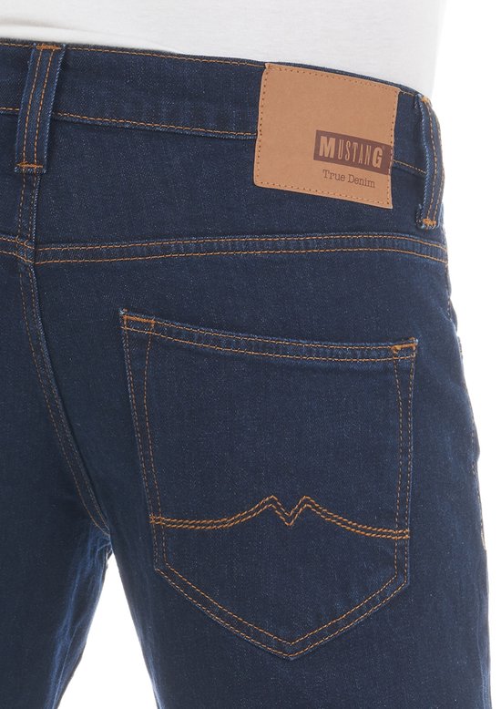 Donkerblauwe denim jeans met oranje stiksels en een bruin Mustang label op de achterkant.