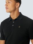 Close-up van een zwarte polo met korte mouwen en een geel logo op de borst.