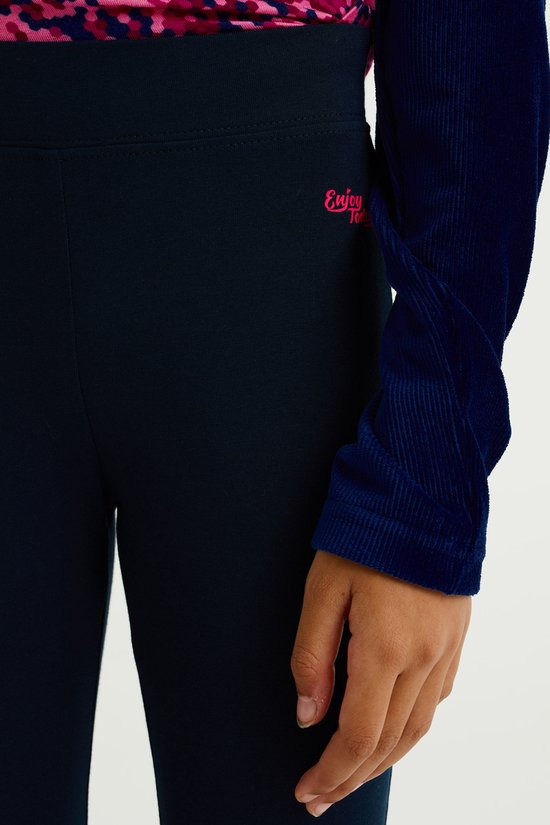 Close-up van donkerblauwe legging met roze tekst 'Enjoy Today'.