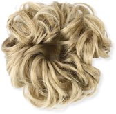 Blond, krullend haarstuk op een witte achtergrond.