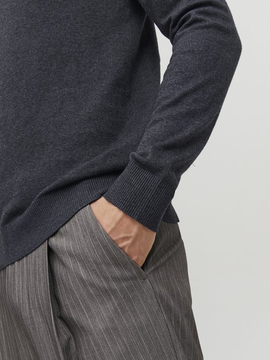 Man met grijze coltrui en broek met krijtstreep.