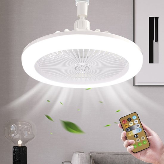 Witte plafondlamp met ventilator, verlicht met warm licht, met afstandsbediening in de hand. Bladeren zweven in de lucht.