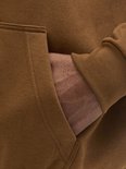 Close-up van de kangoeroezak van een bruine hoodie.