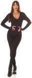 Model staat in zwarte Koucla jumpsuit met lange mouwen, V-hals en duimgaten. Ribgebreid.