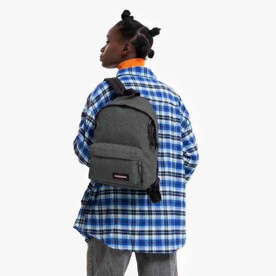 Vrouw met donkergrijze Eastpak Orbit rugzak in denimlook, gedragen over de schouder.