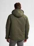 Groene herenparka, achterkant met capuchon en rits, gedragen met grijze jeans.