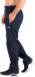 Man in donkerblauwe sportbroek met logo en zwarte sportschoenen.