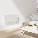 Strakke witte glazen convectorverwarming met digitaal display, gemonteerd aan een witte muur in een woonkamer.