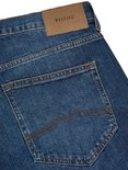 Detail van de achterzakken van een blauwe Mustang jeans met oranje stiksels.