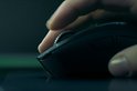 Close-up van een vinger die het scrollwiel van een zwarte Razer gaming muis bedient.