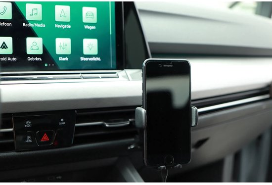 Zwarte telefoonhouder met smartphone in een auto-interieur, voor het ventilatierooster.