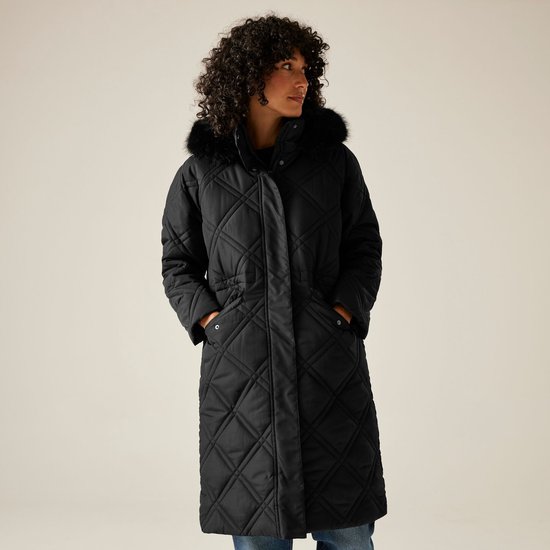 Model met krullend haar draagt een zwarte, langere gewatteerde jas met rits, capuchon met bontrand.