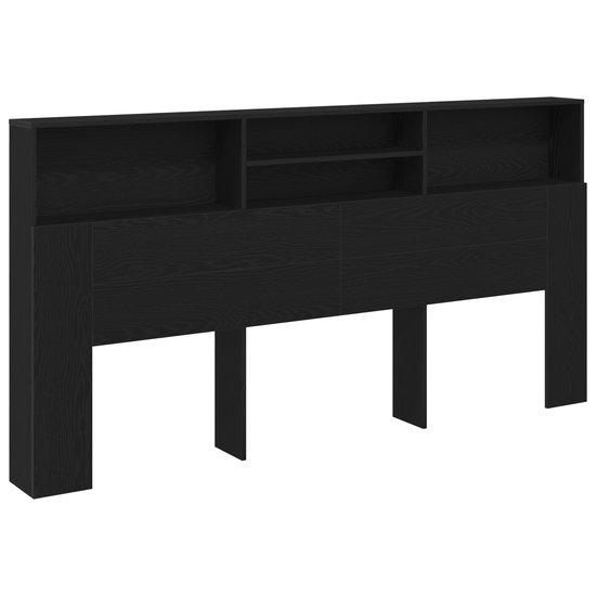 Tête de lit noire avec compartiments ouverts, finition grain de bois et pieds.