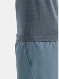 Gedetailleerde weergave van de tailleband van een blauwgrijze sportshort en de onderkant van een donkergrijs Craft sportshirt.